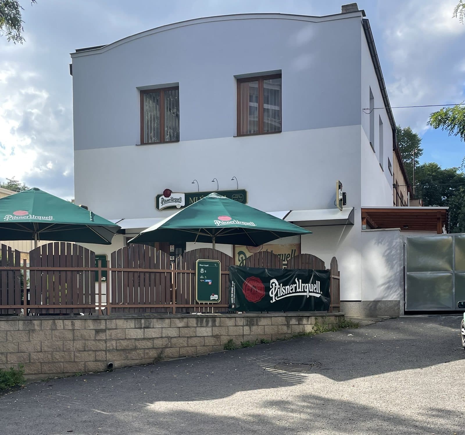 Mlýkárna zvenku — slunečníky Pilsner Urquell a zahrádka